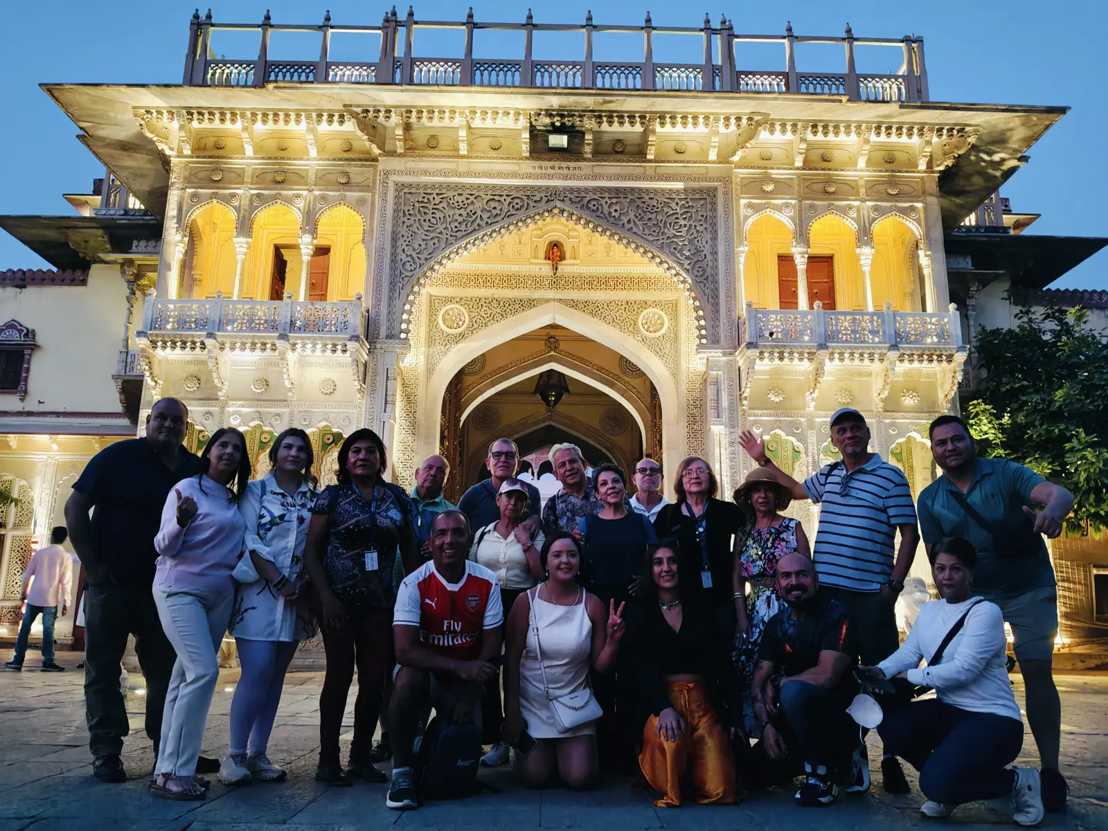 Raah guests at an illuminated City Palace gateway at night